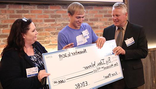 a giant check is handed to the winner of CERD's Big Idea event